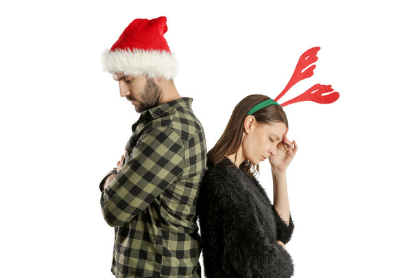 Studio portrét otráveného nešťastného páru v Santa klobouku a sobí čelence. Koncept stresu ze zimních prázdnin. - Fotografie, Obrázek