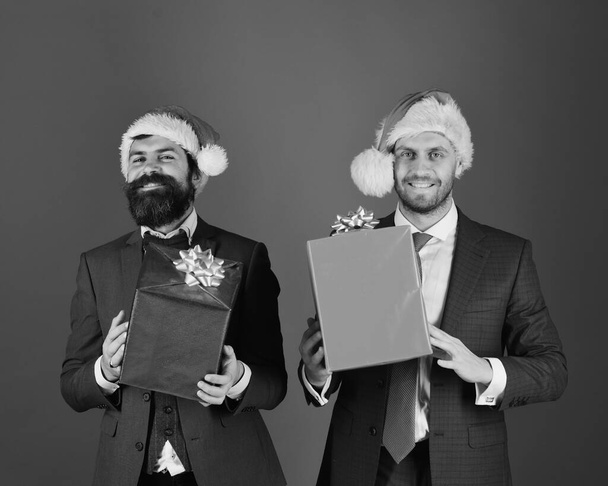 Hombres en trajes inteligentes y sombreros de Santa sobre fondo azul. - Foto, imagen