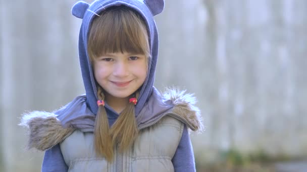 Muotokuva onnellinen lapsi tyttö lämpimissä vaatteissa syksyllä ulkona
. - Materiaali, video