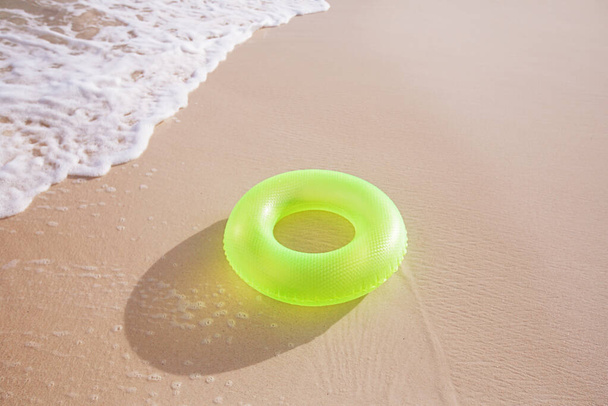 anneau flottant sur la plage de sable avec des vagues
  - Photo, image