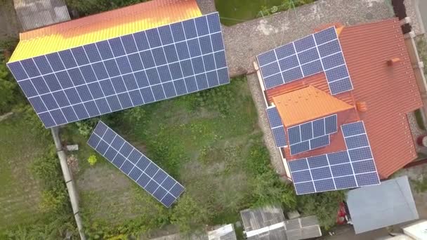 Luchtfoto van een particulier huis met zonnepanelen op het dak. Fotovoltaïsch systeem voor hernieuwbare energie in de bouw en op de grond. - Video