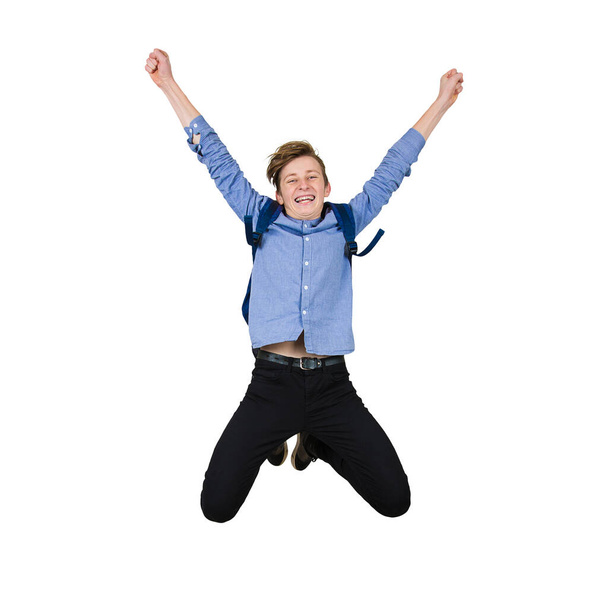 Overjoyed teenage guy jumping high in the air, hands raised up,  - 写真・画像