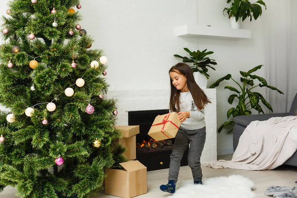 menina decorando a árvore de Natal
 - Foto, Imagem