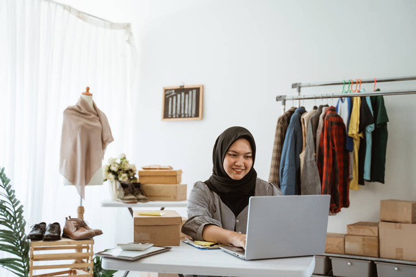 muslim businesswoman online ecommerce shop owner working in her office - Foto, Bild