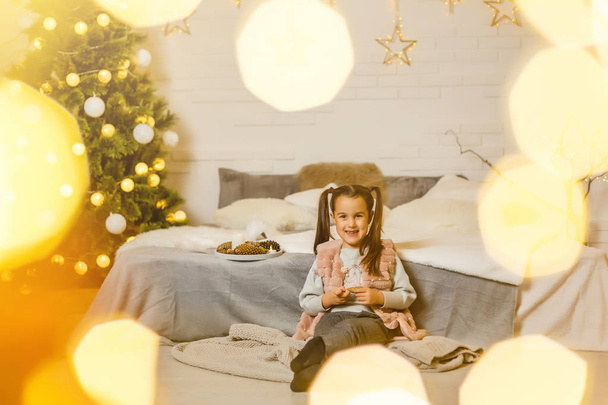 niña en una habitación decorada para Navidad
 - Foto, imagen