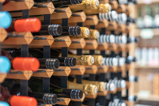wijnflessen in een groot rek in een wijnkelder - Foto, afbeelding