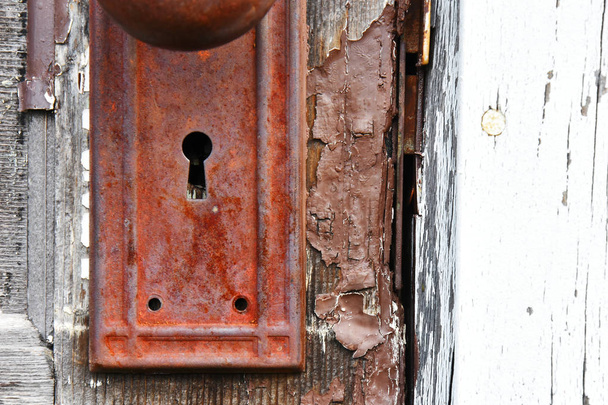 Un'immagine ravvicinata di un antico pomello molto arrugginito su una vecchia porta di legno con peeling vernice marrone
.  - Foto, immagini