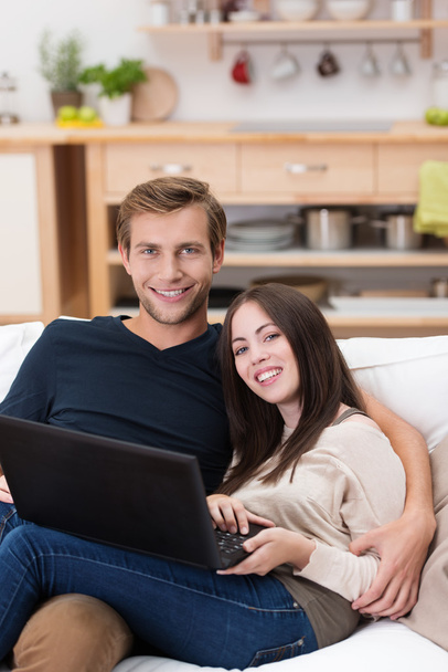 Affectionate young couple using a laptop - Fotó, kép