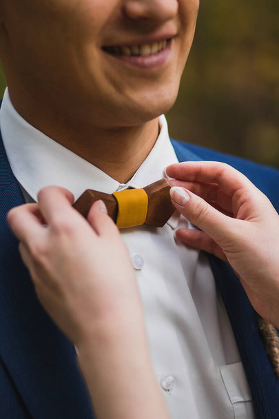 Cuidar novia enderezar corbata de lazo de madera al novio
 - Foto, imagen