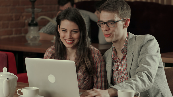 Paar lacht und hält Videokonferenz auf Laptop, während es Wasserpfeife raucht - Filmmaterial, Video