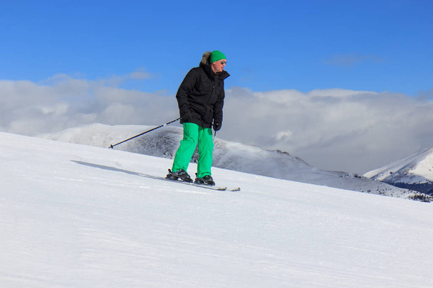 Mies lumessa hiihtäen
 - Valokuva, kuva