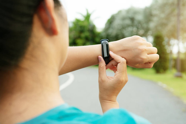 fitness woman runner setting up smartwatch before running. Outdoor exercise activities - Photo, Image