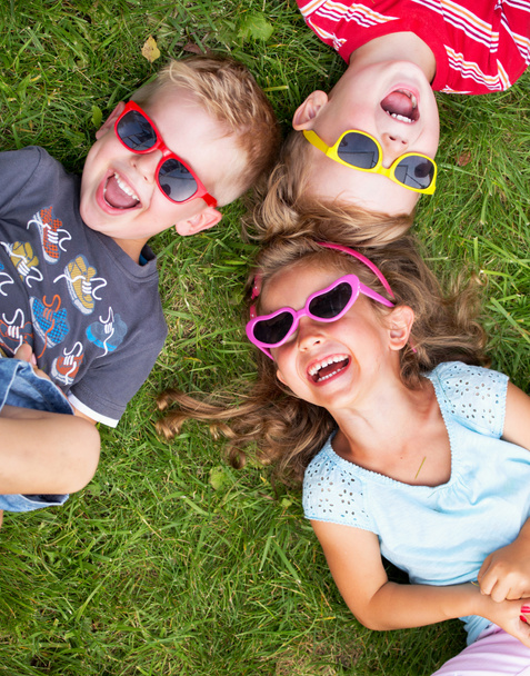 Riendo niños relajándose durante el día de verano
 - Foto, imagen