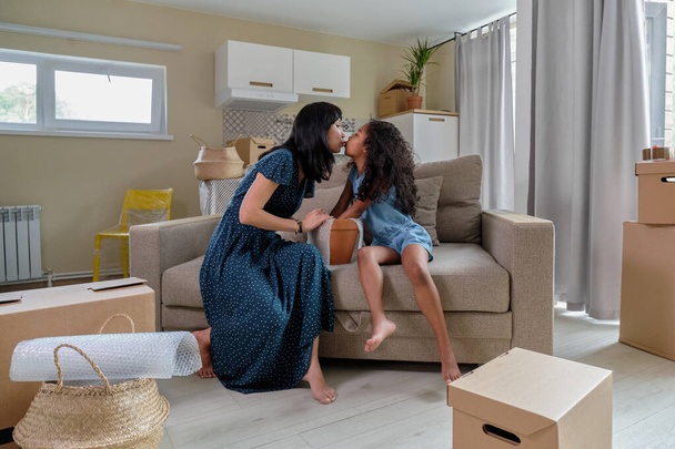 Mom with daughter pack things for relocation, mixed race family, African American daughter and Asian mom. - Foto, Imagem