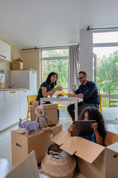 Kiralık Ev 'de Melez Aile Grubu Taşınıyor. Oyuncu Baba 'nın Karton Paket Paketini Taşımaya veya Açmaya Bakış - Fotoğraf, Görsel