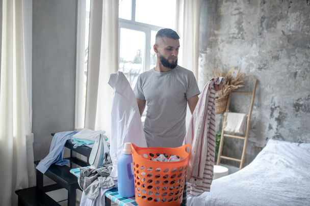 Businessman gathering clothes for laundry at the weekend - Foto, Bild