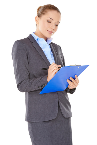 Businesswoman writing notes on a clipboard - Foto, Imagen