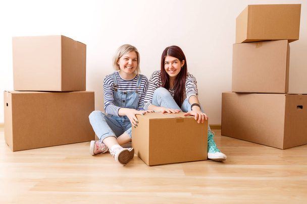 Foto de dos mujeres entre cajas de cartón en un nuevo apartamento - Foto, imagen