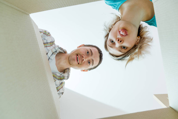 Foto de homem e mulher olhando em caixa de papelão vazia
 - Foto, Imagem