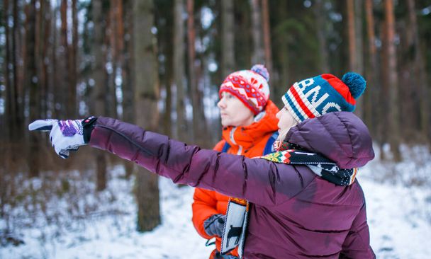 Image de l'homme et de la femme montrant la main en avant dans la forêt d'hiver pendant la journée
 - Photo, image