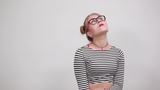 Έφηβος κορίτσι φορώντας ριγέ πουκάμισο κοιτάζοντας προς τα πάνω, κρατώντας τα δάχτυλα κοντά στο κεφάλι - Πλάνα, βίντεο