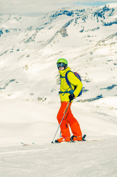 Φωτογραφία του αθλητικού σκι άνθρωπος με φόντο χιονισμένα βουνά κατά τη διάρκεια της ημέρας - Φωτογραφία, εικόνα