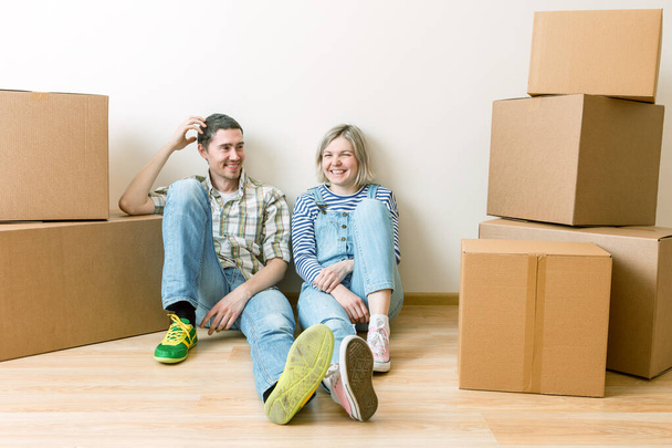 Image of young couple among cardboard boxes in new apartment - Foto, Imagen
