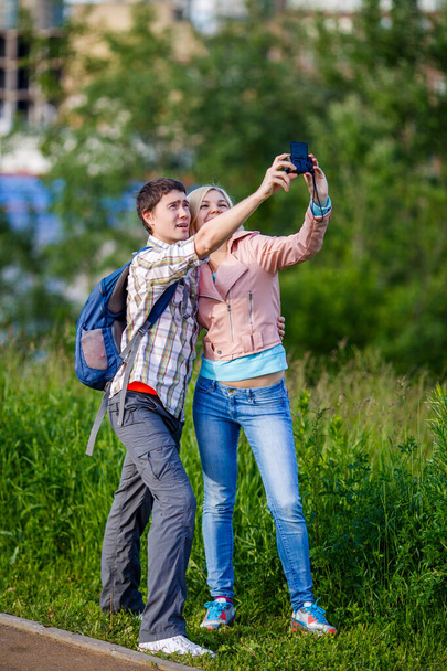 Couple taking a selfie on camera in park - Photo, image