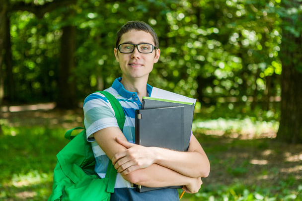 Image of smiling man in glasses with laptop, books - Photo, Image