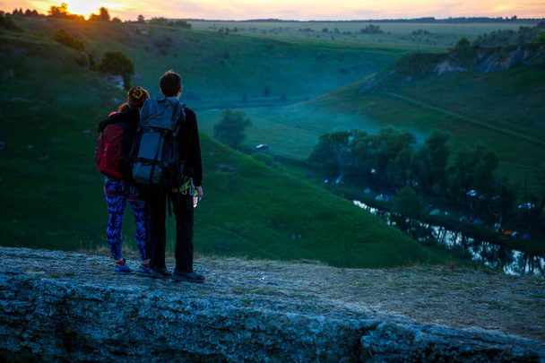 Kuva takaa halaus pari turistia vuorella auringonlaskun aikana
 - Valokuva, kuva