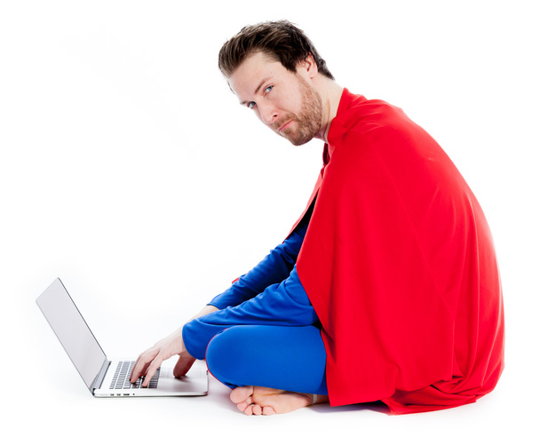 Attractive caucasian man wearing Superman clothes working on laptop - Foto, afbeelding