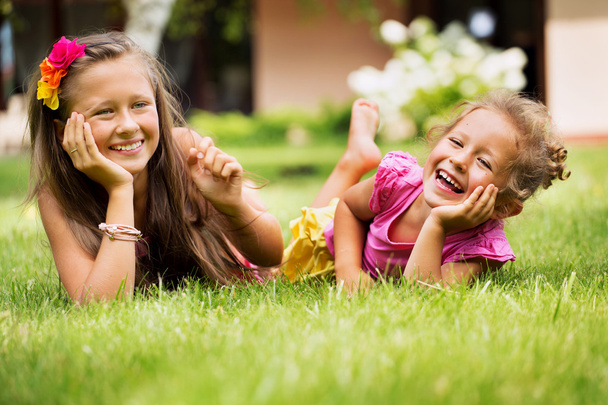 Young sisters playing together in their garden - Foto, immagini