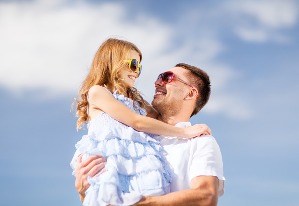 Boldog apa és a gyermek napszemüveg, kék ég alatt - Fotó, kép