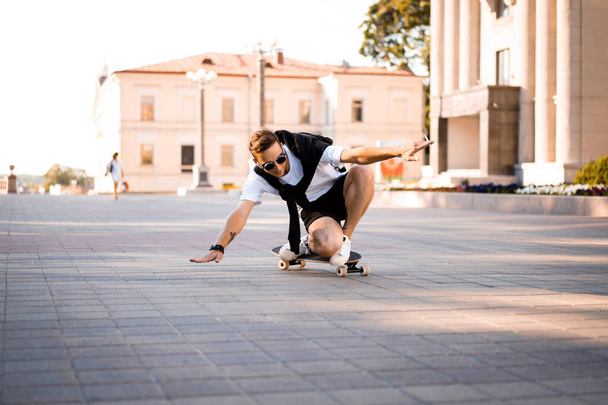 man on a skateboard in the city. skateboarder doing a jump trick in a city place. Lifestyle photoshoot skateboard guy with practis boarding in the city - Fotó, kép