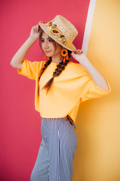 gyönyörű fiatal nő két fonat és szalma kalap  - Fotó, kép