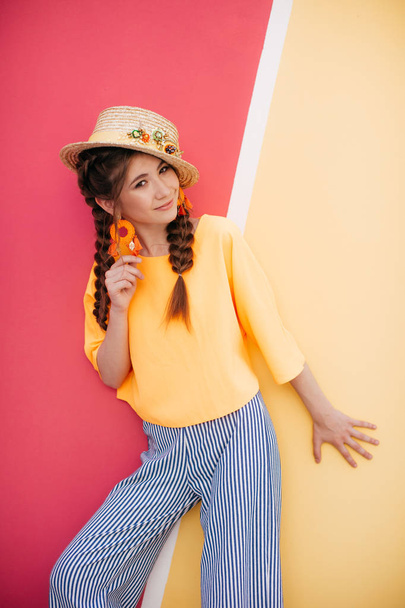 όμορφη νεαρή γυναίκα με δύο πλεξούδες και ψάθινο καπέλο  - Φωτογραφία, εικόνα