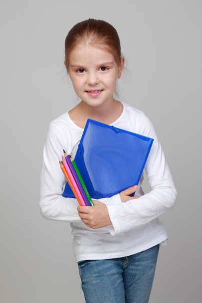 Girl holding a blue folder and pencils - Foto, afbeelding