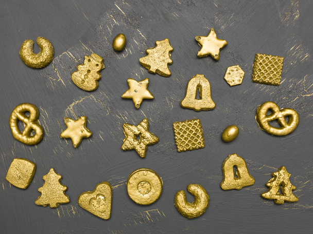 collection of golden christmas cookies on black wooden background - Fotó, kép