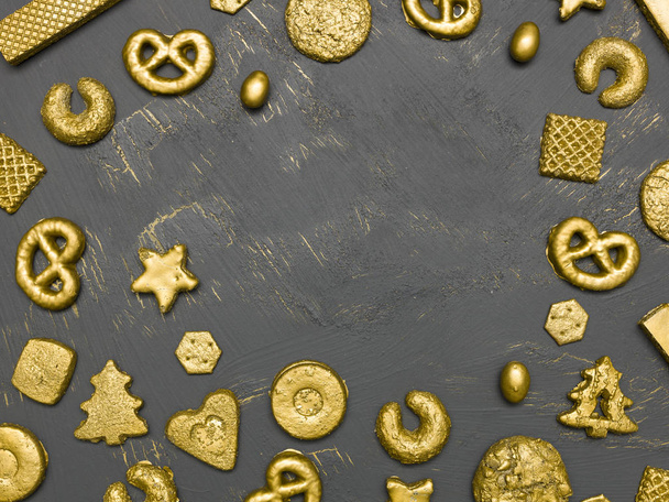 collection of golden christmas cookies on black wooden background - Фото, изображение