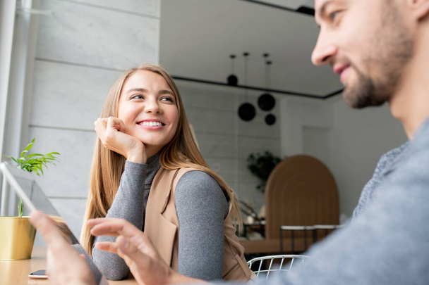Mladá veselá podnikatelka sedí se svým kolegou pomocí touchpad, zatímco oba pracují na obchodním projektu v kavárně - Fotografie, Obrázek