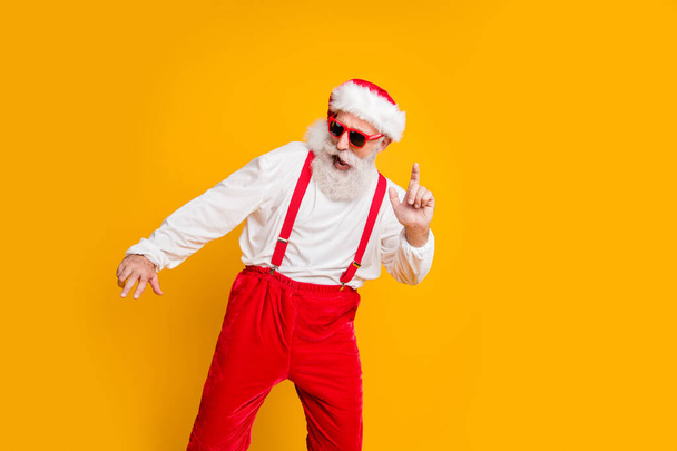 Portrait of funny crazy santa claus in red hat celebrate x-mas christmas magic festive time feel hipster dance wear shirt suspenders isolated over yellow color background - Photo, Image