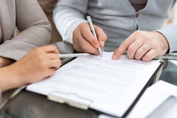 Volwassen man met pen gaat contract of ander financieel document te ondertekenen na onderhandelingen met agent - Foto, afbeelding