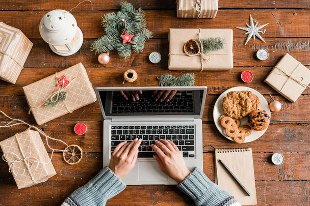 Dłonie kobiety nad laptopem klawiatury surfing w sieci sklepów internetowych, aby zamówić prezenty na Boże Narodzenie - Zdjęcie, obraz