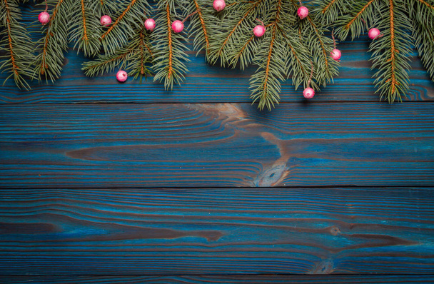 La composición de Año Nuevo. Ramas de árboles sobre un fondo de madera azul. Árbol de Navidad decorado con bayas. Navidad, invierno, nuevo concepto de año 2020. Acostado. Vista superior y espacio de copia
.  - Foto, imagen