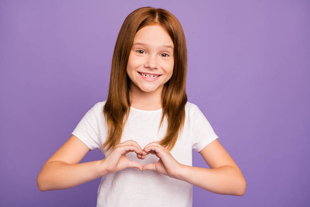 Photo of pretty little ginger lady making heart figure with fingers symbolizing children cardiology safety wear white t-shirt isolated pastel purple background - Foto, immagini