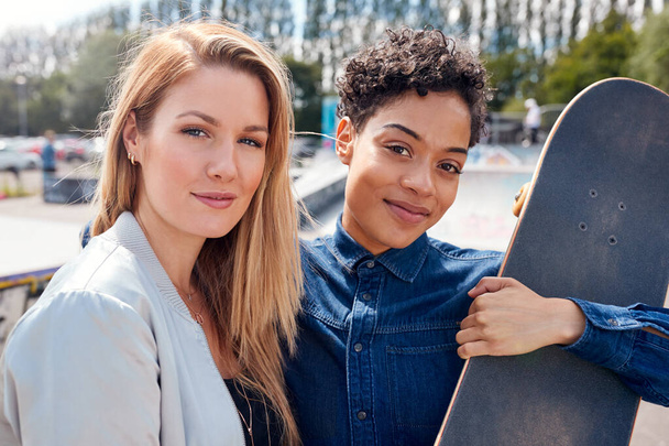 Portrait Of Two Female Friends With Skateboard In Urban Skate Park - Photo, image