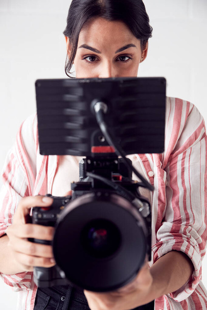 Female Videographer With Video Camera Filming Movie In White Stu - Foto, imagen
