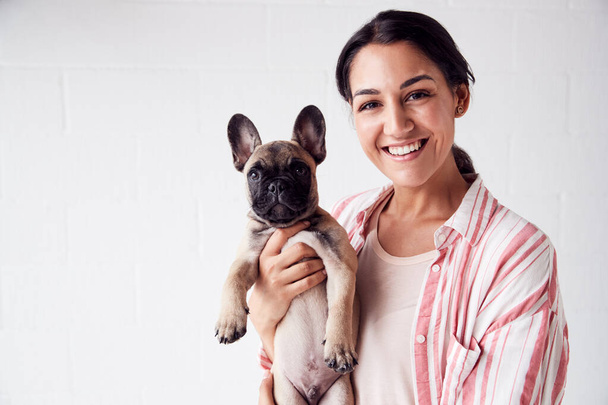 Studio Portrait Of Smiling Young Woman Holding Affectionate Pet  - Foto, Imagem