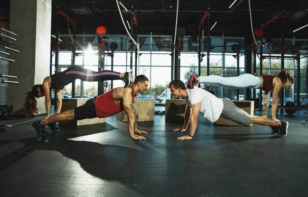 Grupa muskularnych sportowców ćwiczy na siłowni - Zdjęcie, obraz