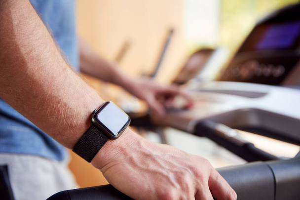 Close Up Of Man Exercising On Treadmill Wearing Smart Watch Checking Mobile Phone - Fotoğraf, Görsel